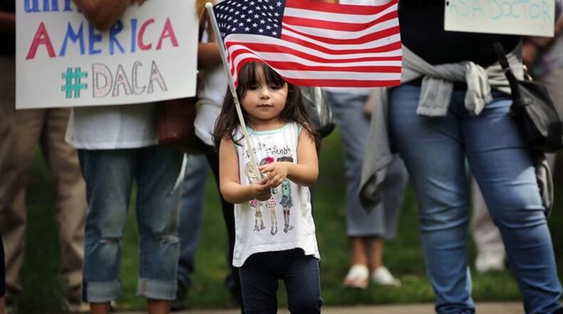 Serenity Moodt, 2, of Painesville waves a flag to protest President Donald Trump’s action to eliminate DACA, which allows young undocumented immigrants to stay in the United States. September 13, 2017 (Gus Chan / The Plain Dealer)
