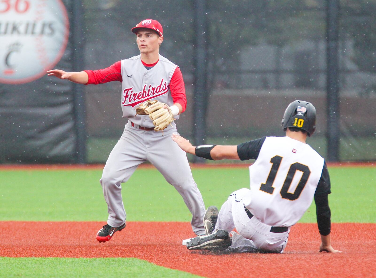Lakota West second baseman A.J. Peterson (8) looks for a throw as Centerville’s Morgan Colopy (10) slides into second base during their Division I regional semifinal at the University of Cincinnati’s Marge Schott Stadium on Thursday. GREG LYNCH/STAFF