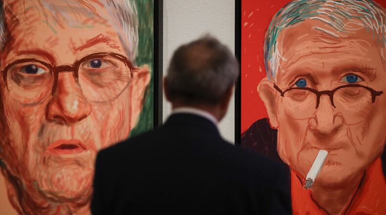 In this Wednesday, June 21, 2017 photo curator Julian Brooks looks at David Hockney's self-portraits, iPad drawings printed on paper, at the Getty Center in Los Angeles. The aspiring artist was 17 when he took pencil to paper in 1954 and sketched out a stunningly mirror-like image of himself as a student at England's Bradford School of Art. In the 63 years since, David Hockney has become world famous not for self-portraits but colorful painted landscapes and brilliant photo collages of everything from backyard swimming pools to scenic desert vistas.(AP Photo/Jae C. Hong)