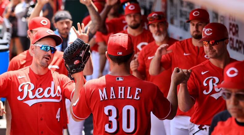 Cincinnati Reds' Tyler Mahle (30) high-fives teammates in the dugout after being pulled during the seventh inning of a baseball game against the San Francisco Giants in Cincinnati, Sunday, May 29, 2022. (AP Photo/Aaron Doster)