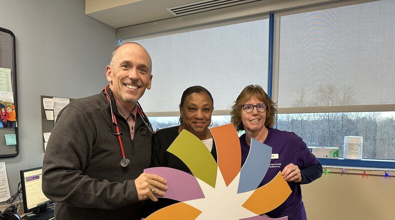 Dr. Greg Eberhart, founding partner for Cornerstone Pediatrics, holds up the Dayton Children's logo with members of his staff. Cornerstone Pediatrics, located in Springboro at 3333 W. Tech Rd., was recently acquired by Dayton Children's, so staff there will become Dayton Children's employees while the office will continue to keep its same name. CONTRIBUTED
