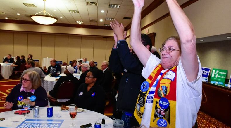 Mary Williams, right, and Will Goins cheer as a state is called in Hillary Clinton’s favor during the Butler County Democratic party election results watch event Tuesday, Nov. 8 at the Marriott ballroom in West Chester Twp. NICK GRAHAM/STAFF