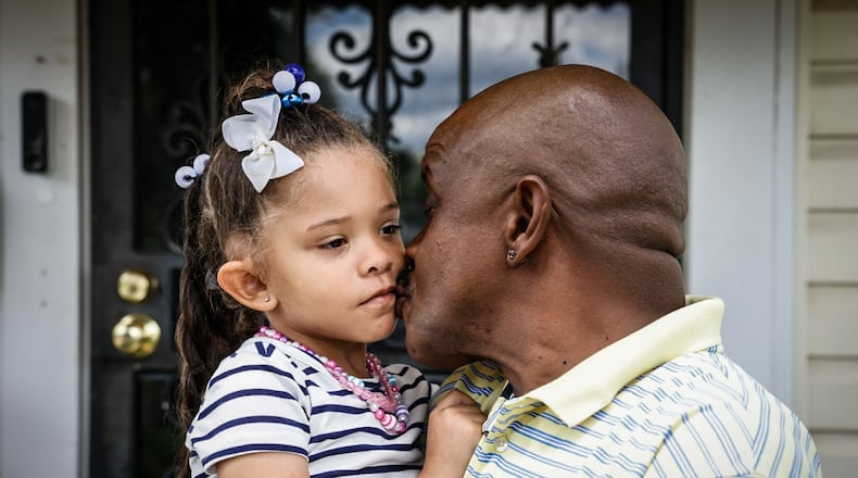 Quintinn Hardwick kisses his five-year-old daughter Arianna Alexis Hardwick before walking to the bus stop in their Dayton neighborhood on June 7, 2024. Hardwick participates in and volunteers with Montgomery County's Father Initiative programs. JIM NOELKER/STAFF