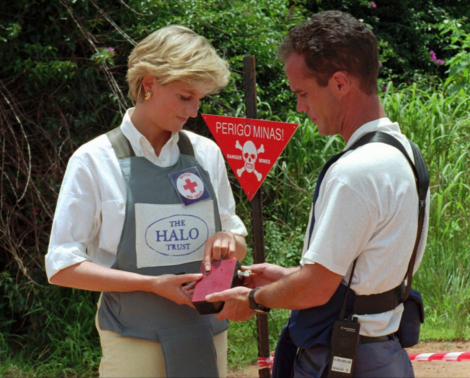 FILE - Diana, Princess of Wales, left, uses a remote switch to trigger the detonation of some explosive ordinance dug up by mine sweepers in Huambo, central Angola, Jan. 15, 1997. (AP Photo/Giovanni Diffidenti, File)