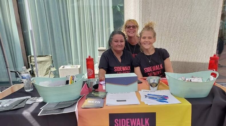 “Sidewalk Soldiers” Resource Table at Courthouse Square. Volunteer Angely Swaney and Board of Directors - Amy Russ and Amanda Thompson.