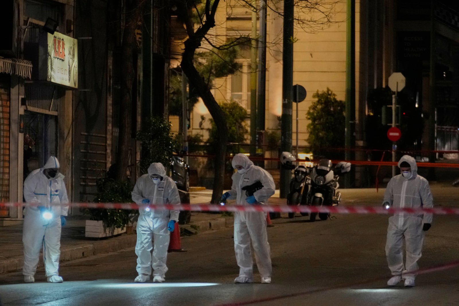 Police officers from the forensics department check the area after a bomb explosion outside of the Hellenic Train offices the company that runs Greece's railway, in Athens, Greece, Friday, April 11, 2025. (AP Photo/Petros Giannakouris)