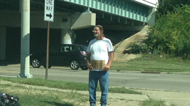 Since Dayton changed its laws on panhandling in August, the city’s intersections have seen an explosion of people begging for money. BRIAN KOLLARS / STAFF