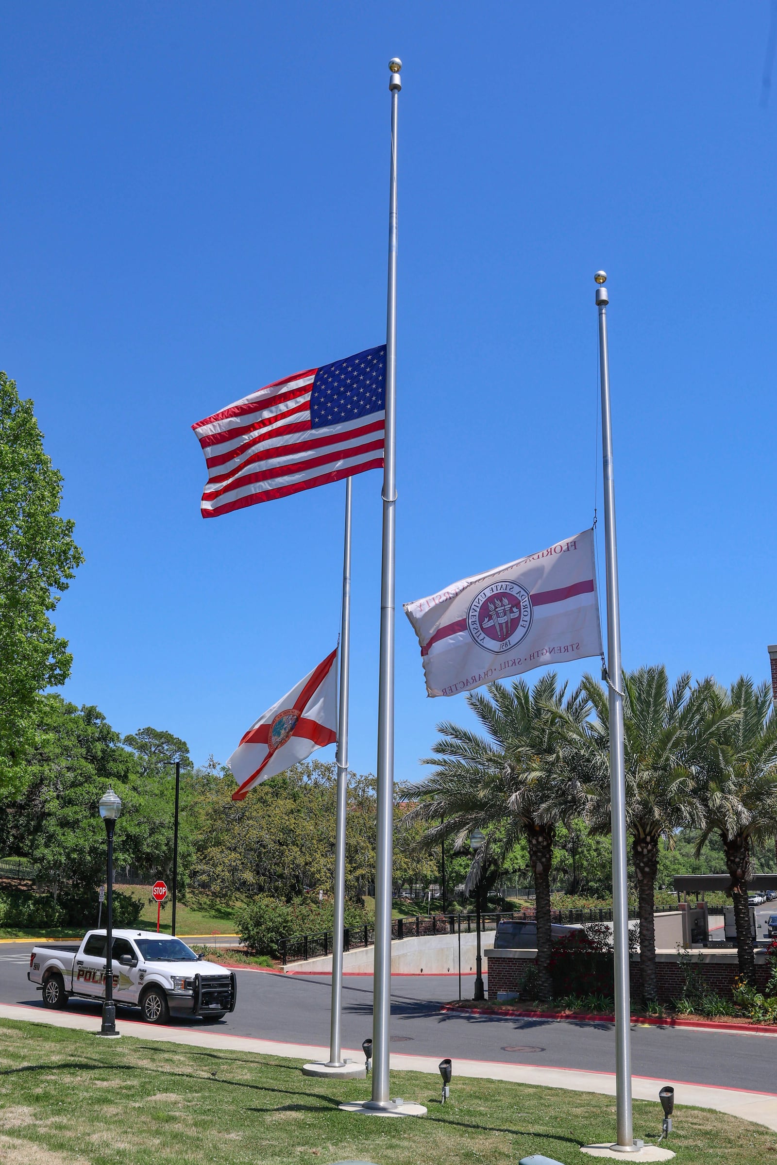 Flags flown at half-staff near the Florida State Student Union building, Tallahassee, Fla., Friday, April 18, 2025. (AP Photo/Gary McCullough)