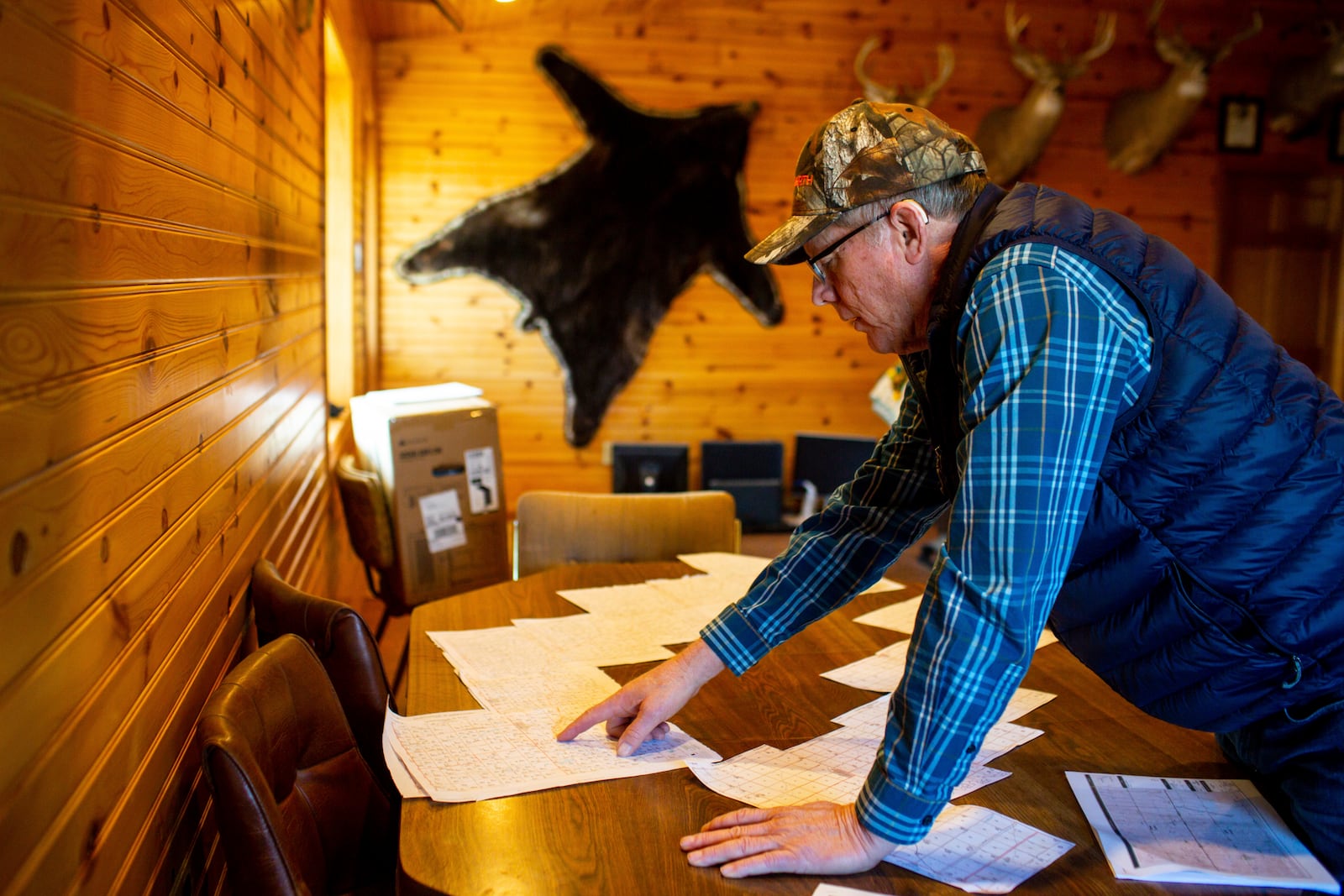 Leroy Braun looks over maps of a proposed Summit Carbon Solutions pipeline which he said had covered the table in his farm office for months in Spink County, S.D., Tuesday, March 11, 2025. (AP Photo/Nicole Neri)