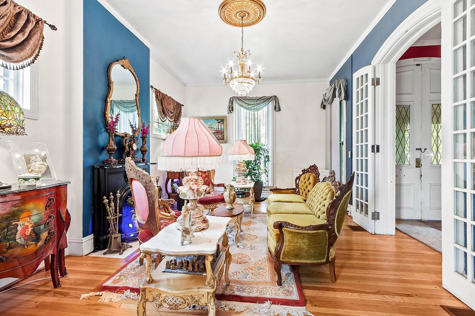 The formal living room is off the entry and has French doors, hardwood flooring and a decorative fireplace.