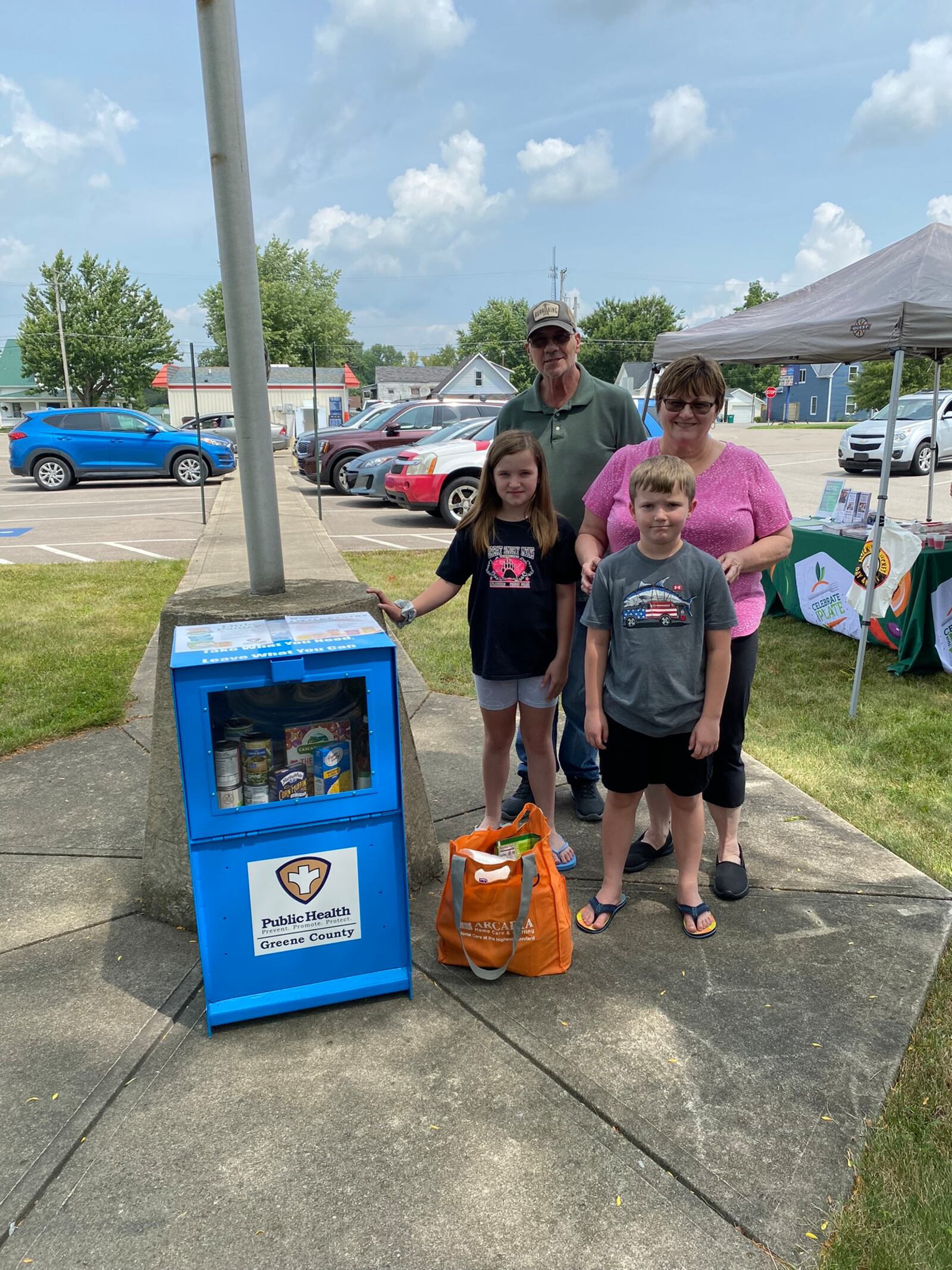A family provides donations at the Jamestown Community Library little pantry unveiling. CONTRIBUTED