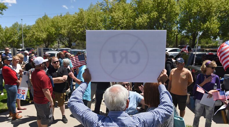 FILE - A man holds up a sign against Critical Race Theory during a protest outside a Washoe County School District board meeting on May 25, 2021, in Reno, Nev. Critical race theory has become a lightning rod for Republicans and an issue in some Election Day races around the country. (Andy Barron/The Reno Gazette-Journal via AP, File)