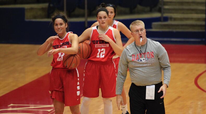 Dayton assistant coach Jeff House, right, helps run practice as Kelley Austria, left, Jenna Giacone, center, watch at UD Arena on Tuesday, Oct. 11, 2016. David