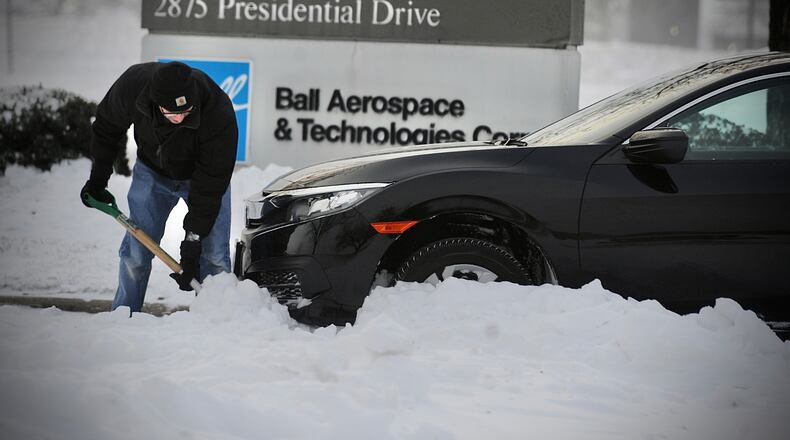A driver shovels his way out of a snowdrift on Presidential Drive in Fairborn early Friday morning, December 23, 2022. MARSHALL GORBY \STAFF