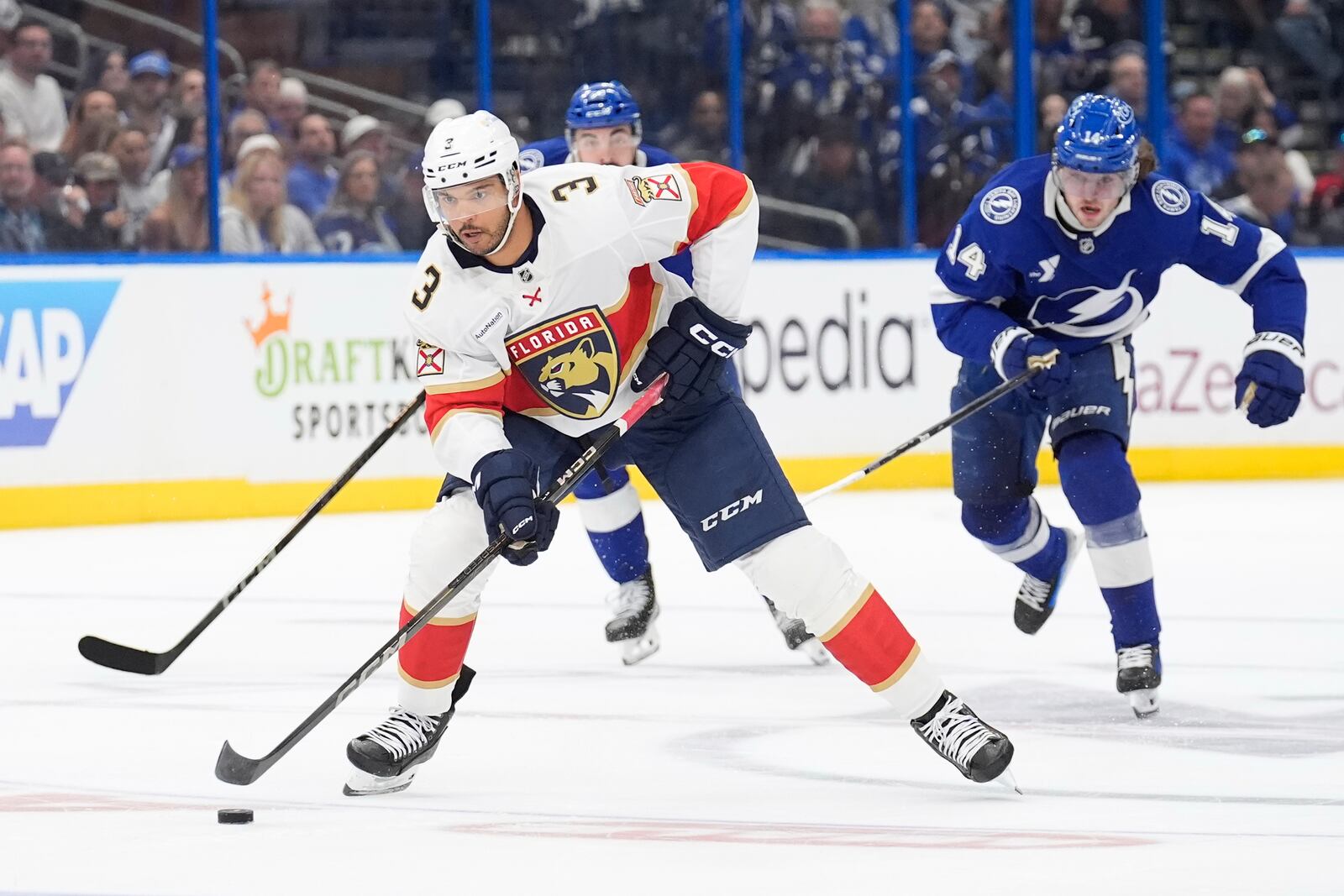 Florida Panthers defenseman Seth Jones (3) carries the puck ahead of Tampa Bay Lightning center Conor Geekie (14) during the first period in Game 2 of an NHL hockey Stanley Cup first-round playoff series, Thursday, April 24, 2025, in Tampa, Fla. (AP Photo/Chris O'Meara)