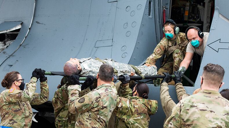 Air Force medical personnel unload mannequins from a C-17 Globemaster based out of McGuire Air Force Base, New Jersey, as part of U.S. Transportation Command’s Ultimate Caduceus 21 field training exercise at Wright-Patterson Air Force Base April 29. U.S. AIR FORCE PHOTO/WESLEY FARNSWORTH