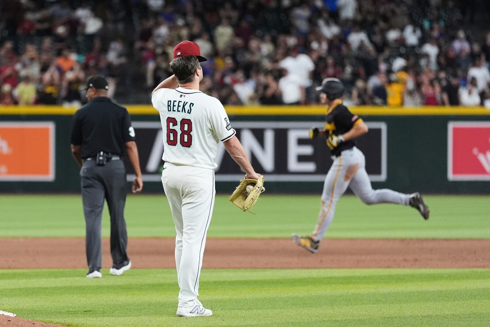 Arizona Diamondbacks pitcher Jalen Beeks (68) pauses in the infield after giving up a three-run home run to Pittsburgh Pirates' Bryan Reynolds, right, during the eighth inning of a baseball game Tuesday, May 27, 2025, in Phoenix. (AP Photo/Ross D. Franklin)