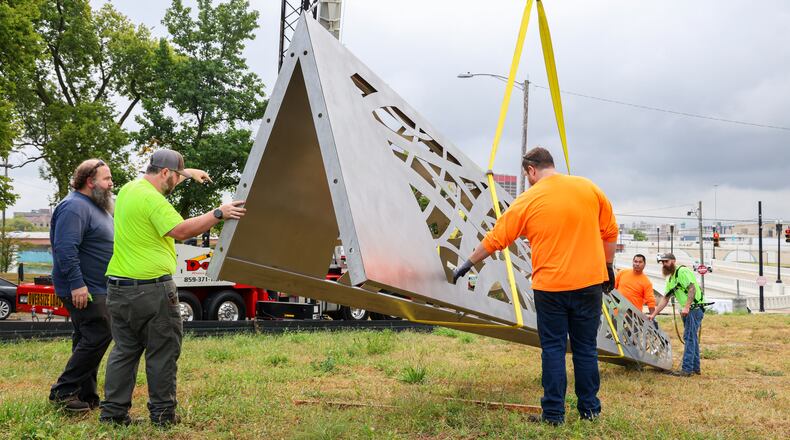 Workers from Budde Sheet Metal Works move one of the 30-foot spires at the Montgomery County Law Enforcement Memorial beside the Dayton Masonic Center. BRYANT BILLING / STAFF