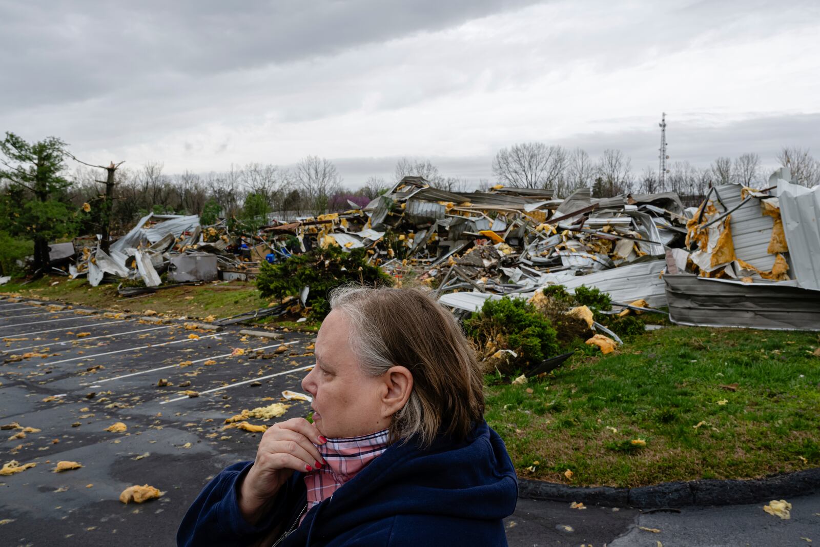 Dana Hardin, a 25-year former employee of Gordon-Hardy, which was destroyed, looks on near the debris of the KEP Electric building after a tornado passed through an industrial industrial park on Thursday, April 3, 2025, in Jeffersontown, Ky. (AP Photo/Jon Cherry)