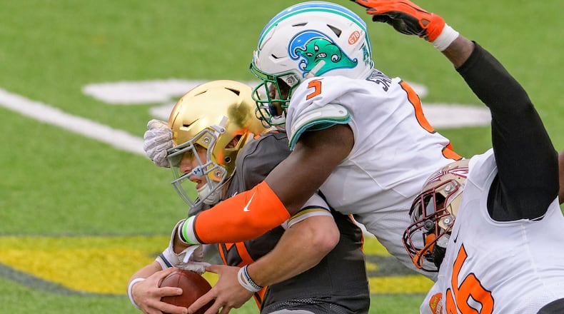 American Team defensive lineman Cameron Sample of Tulane (5) sacks National Team quarterback Ian Book of Notre Dame (12) with the help of American Team Janarius Robinson of Florida State (96) during the NCAA Senior Bowl college football game in Mobile, Ala., Saturday, Jan. 30, 2021. (AP Photo/Matthew Hinton)