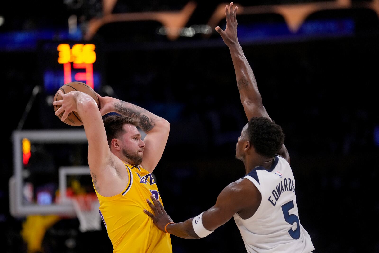 Los Angeles Lakers guard Luka Doncic (77) looks to pass around Minnesota Timberwolves guard Anthony Edwards (5) during the first half of Game 2 of an NBA basketball first-round playoff series in Los Angeles, Tuesday, April 22, 2025. (AP Photo/Eric Thayer)