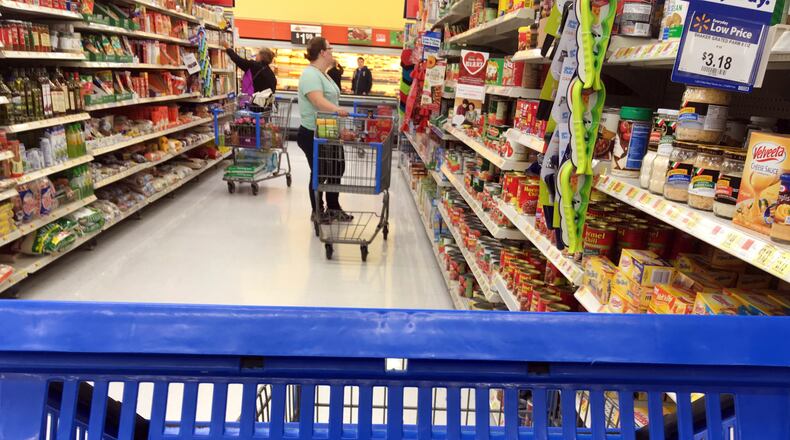 FILE- In this June 5, 2017, file photo, customers shop for food at Walmart in Salem, N.H. Walmart reports financial results Tuesday, Feb. 20, 2018. (AP Photo/Elise Amendola, File)