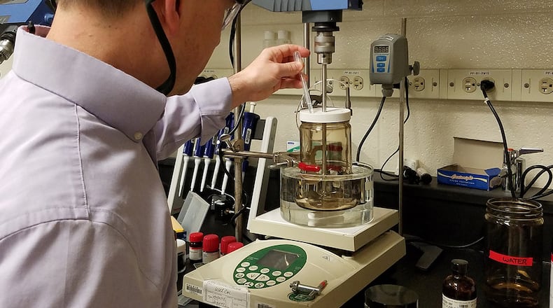 Air Force Research Laboratory Materials Engineer Dr. Larry Brott demonstrates the process through which he microencapsulates chemiluminescent materials for use in applications such as multi-use glow stick “crayons.” (U.S. Air Force photos/Holly Jordan)