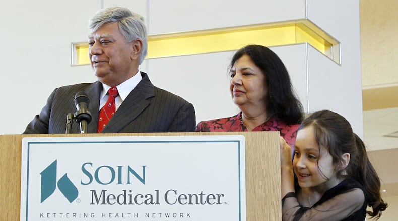 Raj and Indu Soin's granddaughter Mira, then 8, peeks around the lectern as Raj Soin speaks at a ribbon-cutting ceremony for the Soin Medical Center in this February 2012 file photo.