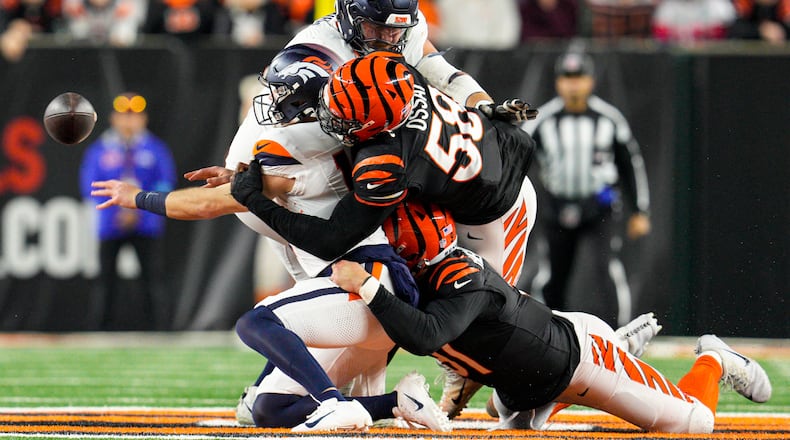Denver Broncos quarterback Bo Nix (10) is sacked by Cincinnati Bengals defensive end Joseph Ossai (58) and defensive end Trey Hendrickson (91) during the first half of an NFL football game in Cincinnati, Saturday, Dec. 28, 2024. (AP Photo/Jeff Dean)
