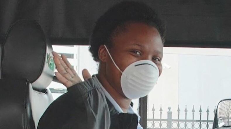 RTA fixed-route driver, Alexis Appleberry, welcomes riders onto the bus with a smile and a face mask on.
