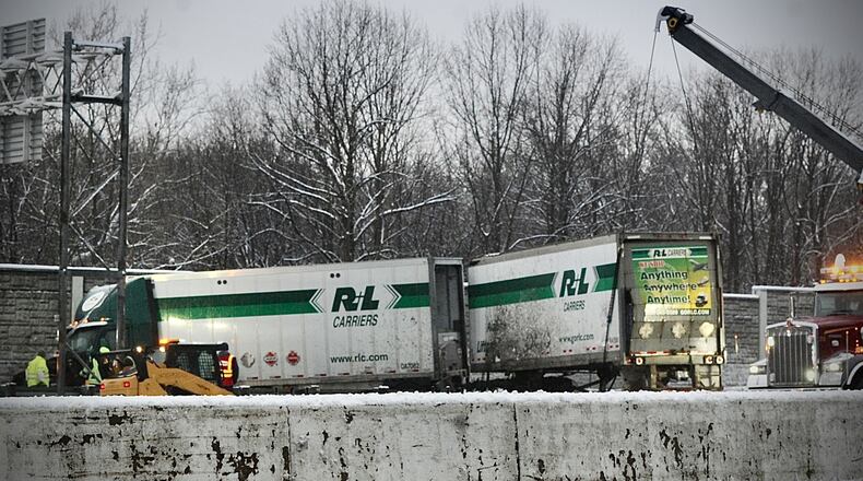 Crews work to remove a semi with two trailers that struck a fence on the exit ramp from I 75 south to 70 early Wednesday morning, January 25, 2023 MARSHALL GORBY\STAFF