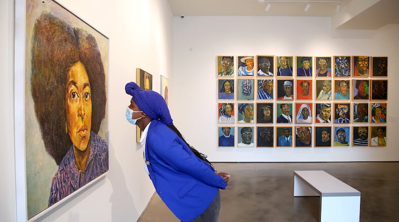 Cydnie King, executive assistant, at the Contemporary Dayton looks at a painting in an exhibition of the work of Curtis Barnes, Sr. The Co has opened in its new home at the Dayton Arcade. The Co has nearly doubled in size to 6,224 square feet at the Dayton Arcade, with five galleries incorporated into the new space. LISA POWELL / STAFF