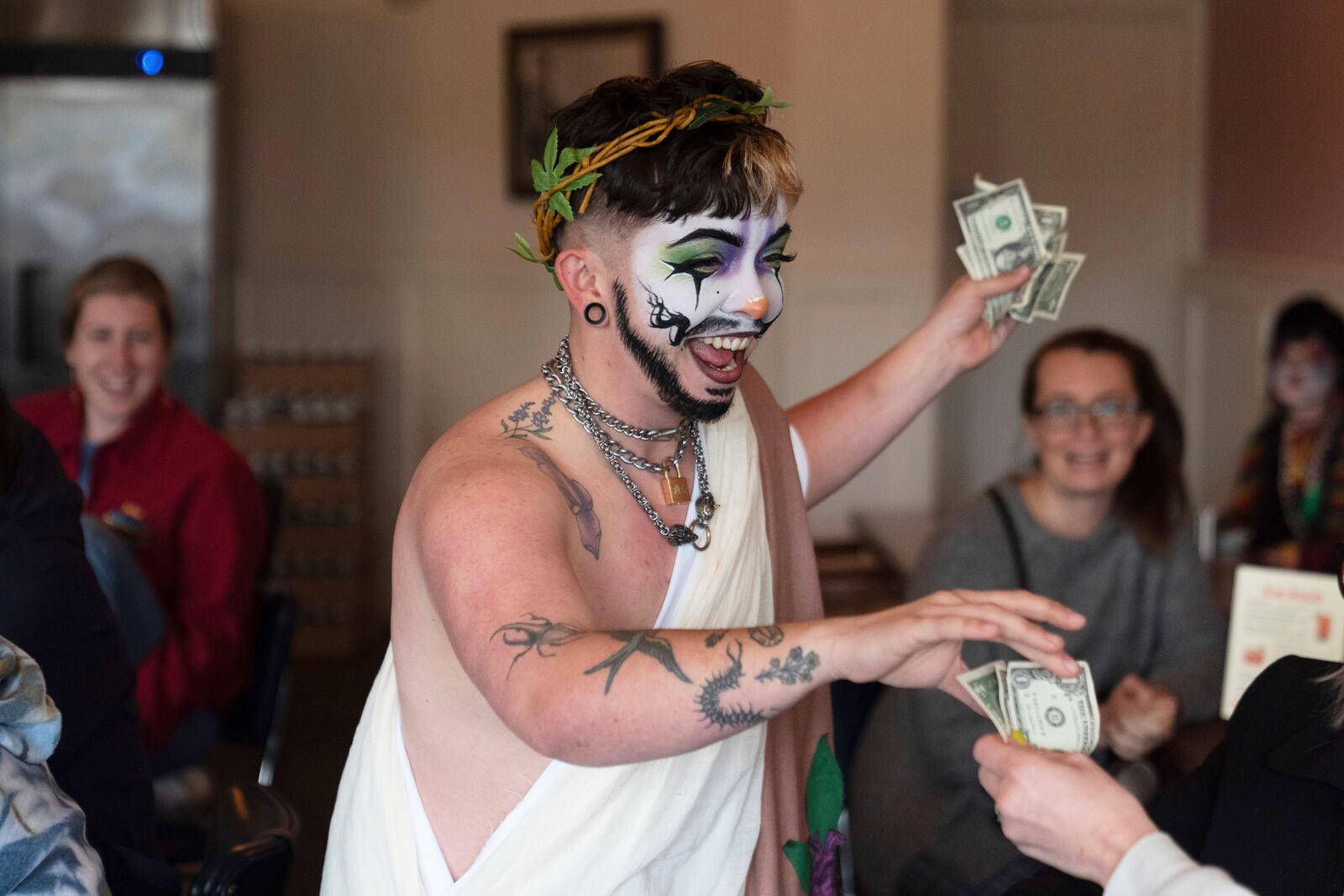 Drag performer Ed Du'Bull receives money from audience members during a "blaze and praise" drag brunch at Bar Carlo on Sunday, April 20, 2025, in Portland, Ore. (AP Photo/Jenny Kane)
