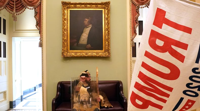 A protester with a tactical shield sits in a hallway of the Capitol  in Washington on Wednesday, Jan. 6, 2020, after supporters of President Donald Trump breached security and entered the building. A mob of people loyal to President Trump stormed the Capitol on Wednesday, halting Congress’s counting of the electoral votes to confirm President-elect Joe Biden’s victory as the police evacuated lawmakers from the building in a scene of violence, chaos and disruption that shook the core of American democracy. (Erin Schaff/The New York Times)