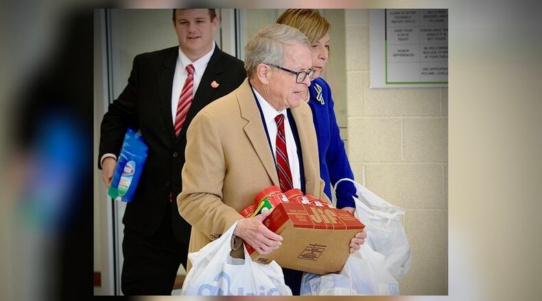 Ohio Gov. Mike DeWine, with first lady Fran DeWine, carry in peanut butter, cleaning supplies, clothes and diapers for children to the Emerge Recovery and Trade Initiative to be transported to help Ukrainian refugees. On Friday, April 1, 2022, the governor met with charitable organizations near Xenia regarding help for Ukrainian refugees. MARSHALL GORBY\STAFF