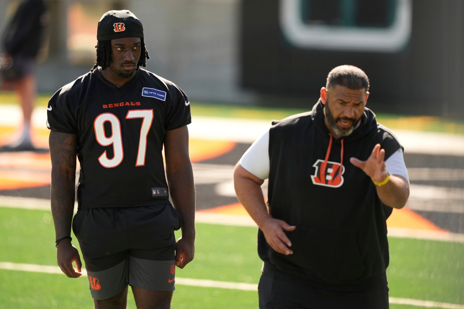 Cincinnati Bengals defensive end Shemar Stewart (97) observes a drill with Jerry Montgomery, defensive line and run game coordinator, right, during the NFL football team's rookie minicamp on Friday, May 9, 2025, in Cincinnati. (AP Photo/Carolyn Kaster)