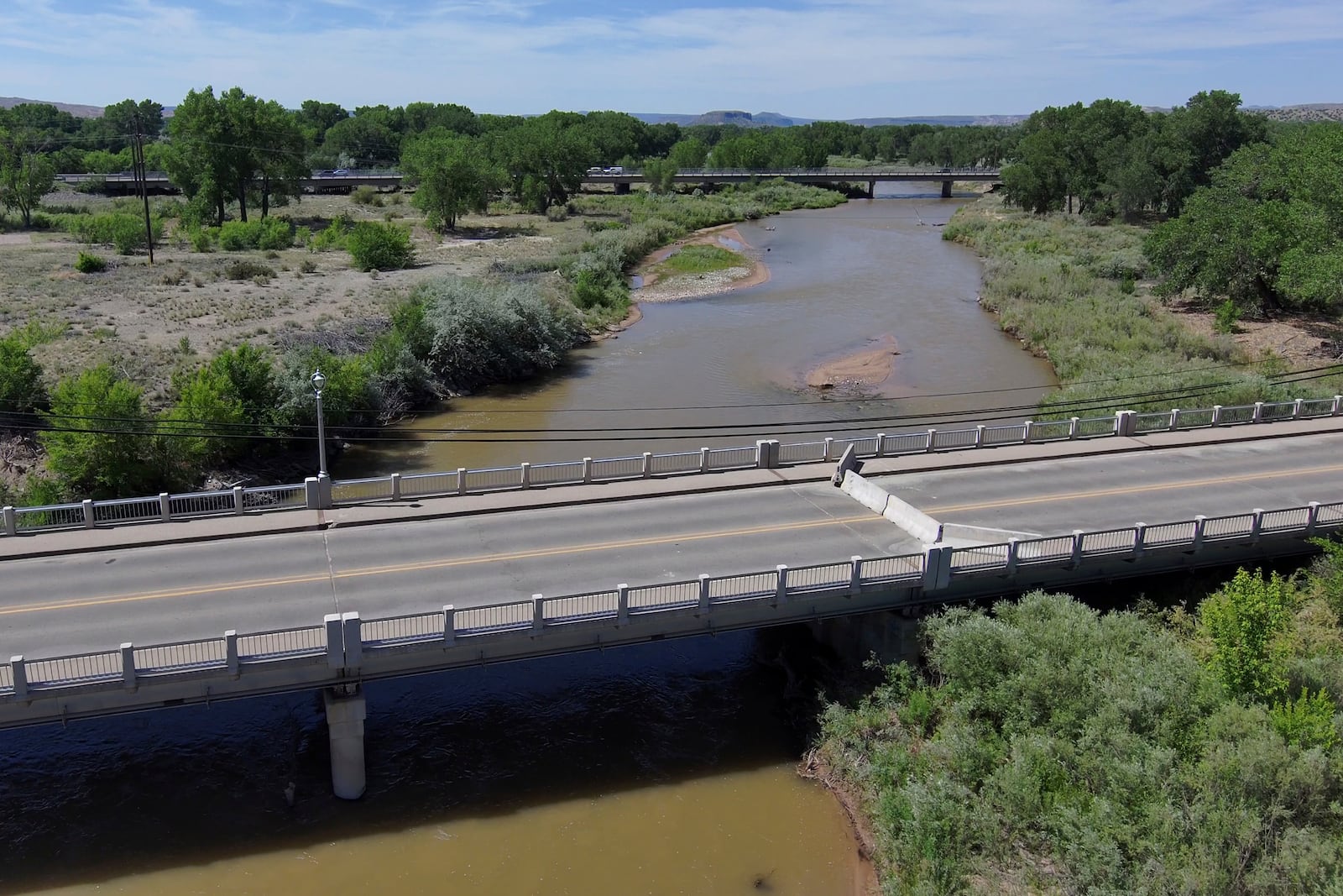 A historic bridge that crosses the Rio Grande is closed ahead of the monsoon due to concerns about a concrete pier being further scoured by high river flows in Española, New Mexico, on June 13, 2025. (AP Photo/Susan Montoya Bryan)