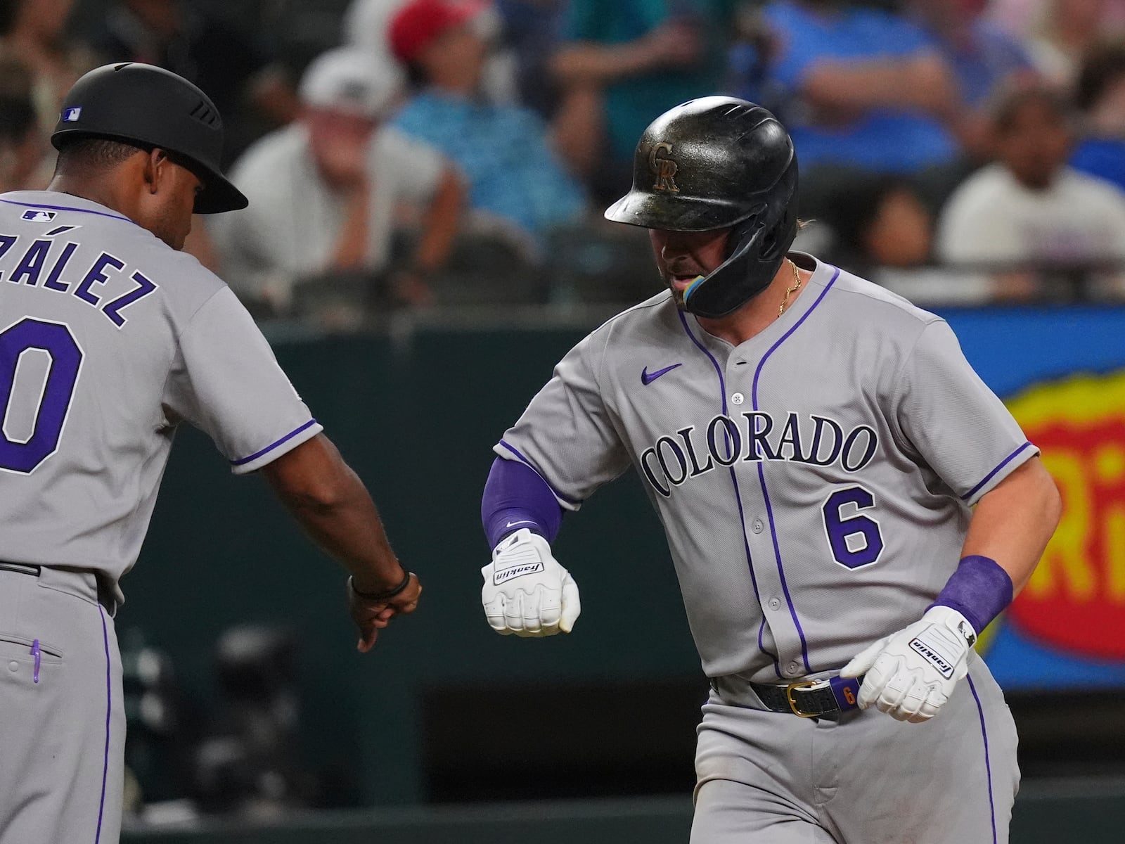 Colorado Rockies' Kyle Farmer (6) celebrates his home run with third base coach Andy González (70) during the sixth inning of a baseball game against the Texas Rangers, Wednesday, May 14, 2025, in Arlington, Texas. (AP Photo/LM Otero)