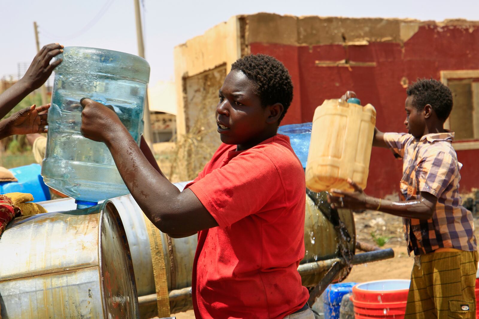 People fill a container by water due to water outages in Khartoum, Sudan, Sunday, May 25, 2025. (AP Photo)