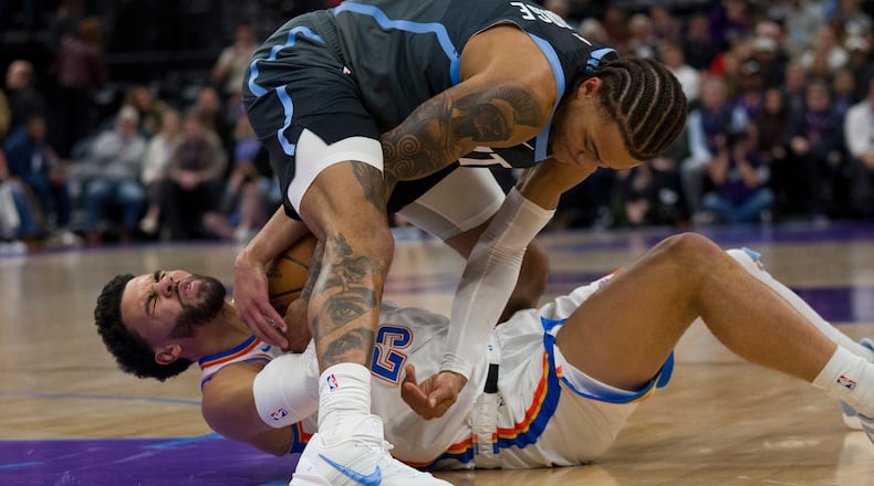 Utah Jazz guard Keyonte George, top, and Oklahoma City Thunder guard Ajay Mitchell (25) fight for the ball during the first half of an NBA basketball game Sunday, Dec. 7, 2025, in Salt Lake City. (AP Photo/Bethany Baker)