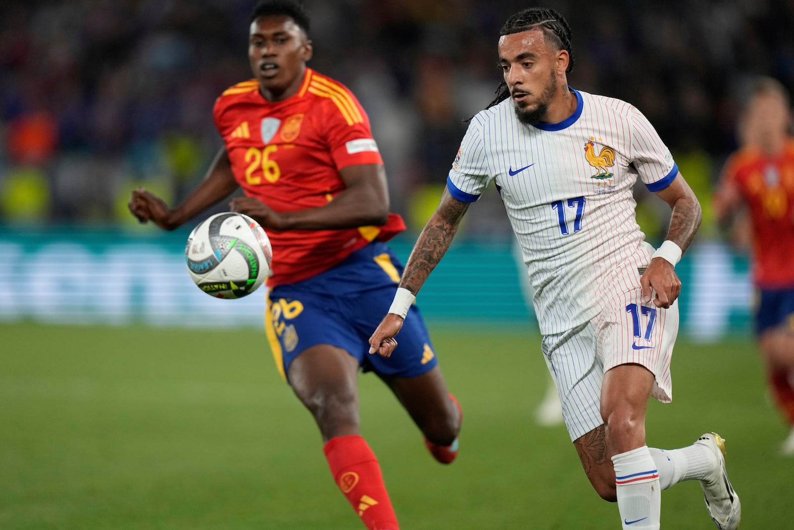 France's Malo Gusto in action in front of Spain's Samu Aghehowa during the Nations League semifinal soccer match between Spain and France in Stuttgart, Germany, Thursday, June 5, 2025. (AP Photo/Matthias Schrader)