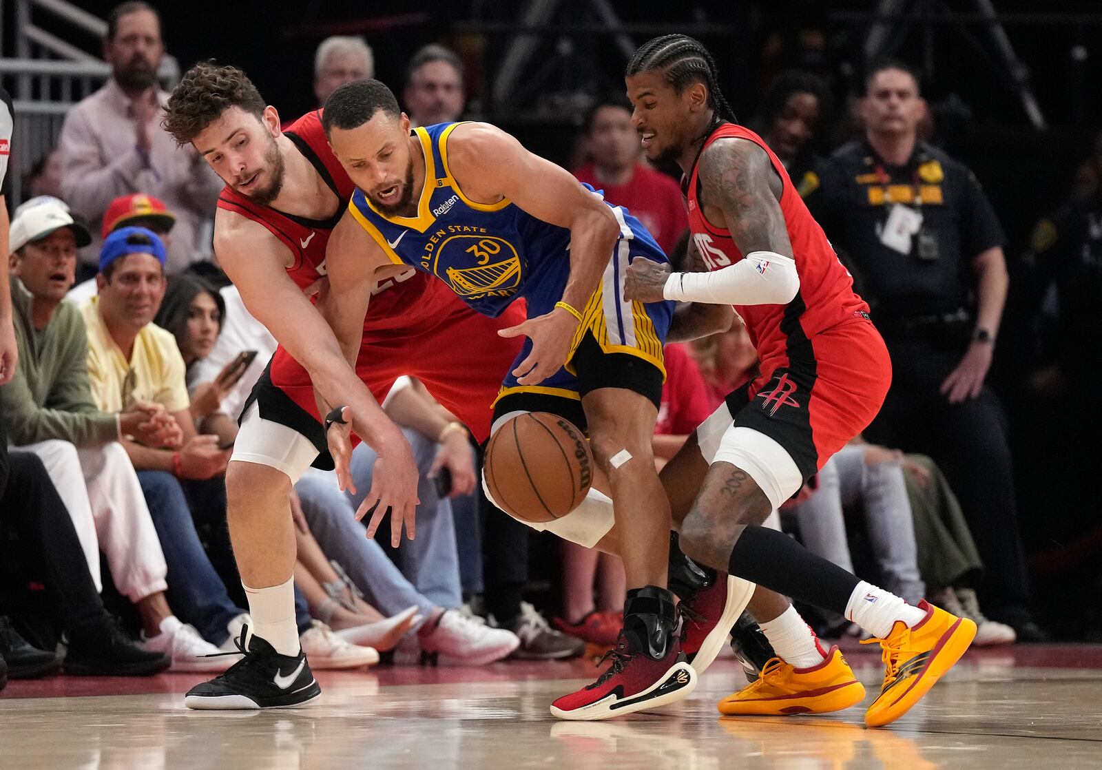Golden State Warriors guard Stephen Curry, center, battles for a loose ball against Houston Rockets center Alperen Sengun, left, and, Rockets guard Jalen Green, right during the first half of Game 2 of an NBA basketball first-round playoff series against the Houston Rockets in Houston, Wednesday, April 23, 2025. (AP Photo/Karen Warren)