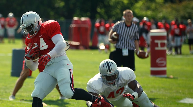 Ohio State tight end Rashod Berry, left, is tackled by linebacker Justin Hilliard during practice at the Coffey Road fields on Friday, Aug. 14, 2015, in Columbus. David Jablonski/Staff