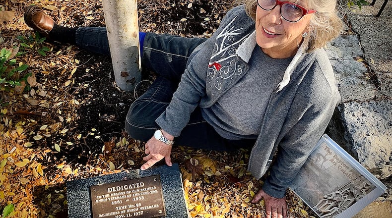 Volunteer Elaine Herrick sits by one of the markers dedicated to veterans along N. Patterson Blvd. that she help to find, clean, repair and refurbish. MARSHALL GORBY\STAFF