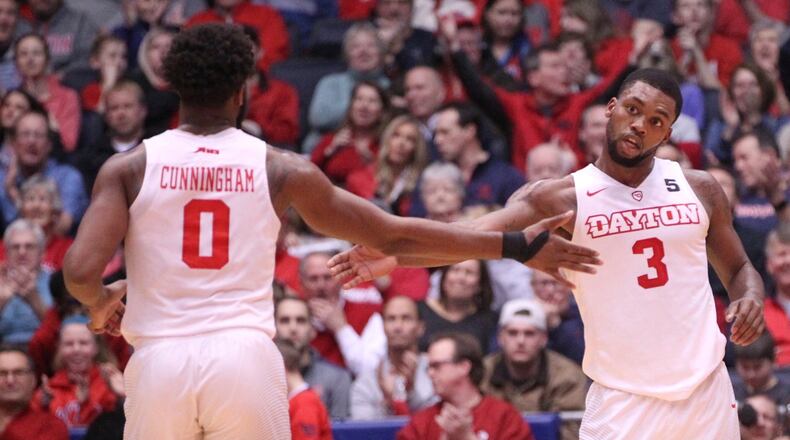 Dayton’s Trey Landers, right, slaps hands with Josh Cunningham after making a 3-pointer against Fordham on Saturday, Feb. 17, 2018, at UD Arena. David Jablonski/Staff