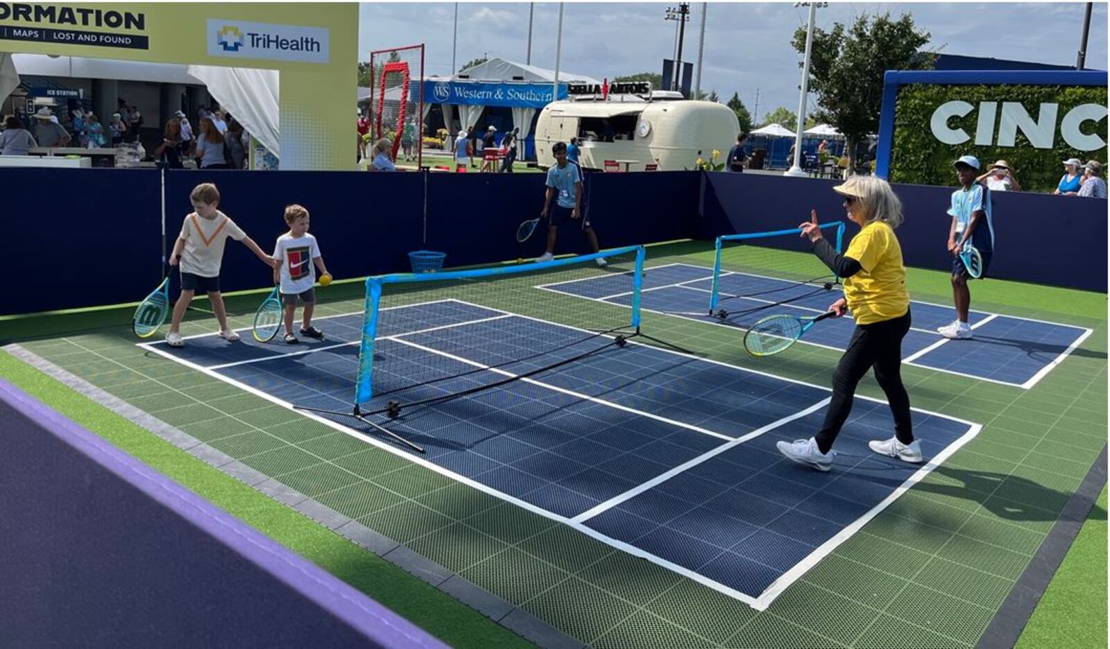 As action continues on Center Court and other courts during the Western & Southern Open, young fans can play on a mini tennis court in the Fan Zone, a new amenity at the tournament. ED RICHTER/STAFF