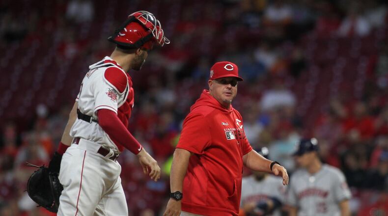 Reds pitch coach Derek Johnson, right, talks to catch Curt Casali after a mound visit during a game against the Astros on Monday, June 17, 2019, at Great American Ball Park in Cincinnati. David Jablonski/Staff