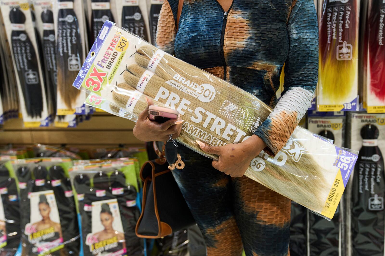 Hair stylist India Sands holds a pack of synthetic braiding hair that is made in China as she shops at Chapel Beauty, a beauty supply store in Decatur, Ga., Monday, May 5, 2025. (AP Photo/Stephanie Scarbrough)