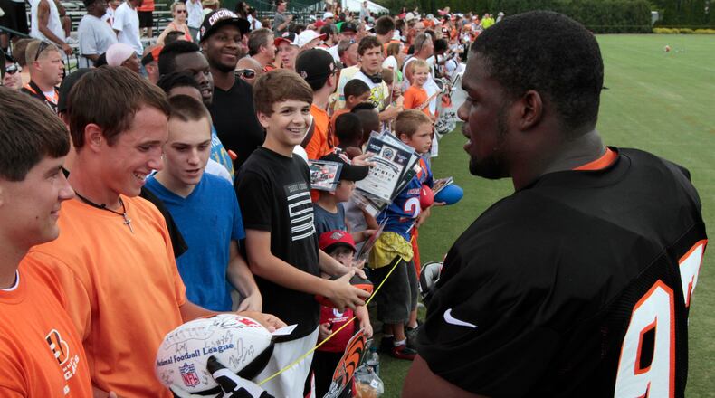 Cincinnati Bengals defensive tackle Geno Atkins (97) signs autographs after the NFL football team's first practice at training camp on Friday, July 27, 2012, in Cincinnati. (AP Photo/Al Behrman)
