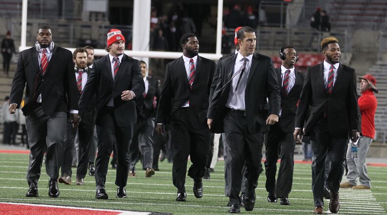 Ohio State defensive coordinator Luke Fickell, second from right, arrives at Ohio Stadium with Buckeye defenders before a game against Minnesota on Saturday, Nov. 7, 2015, in Columbus. David Jablonski/Staff